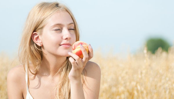 12535659 - young happy woman in wheat field with peach. summer picnic